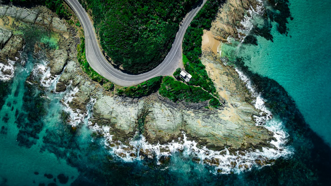 Aerial view of a road winding around a rocky cove